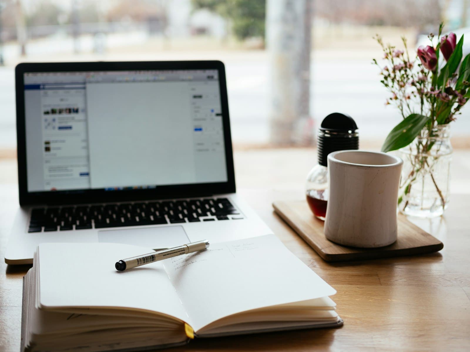 Notebook e caderno de anotações em uma mesa de estudos