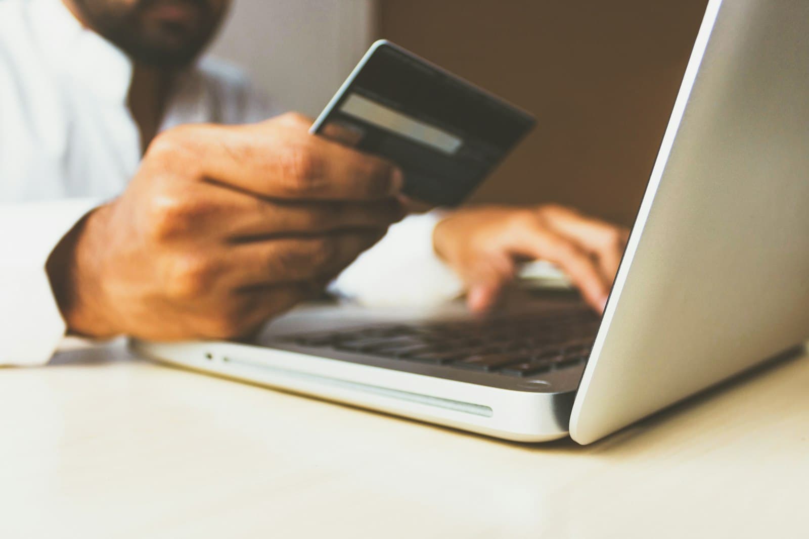 Cliente comprando online com cartão em frente ao notebook